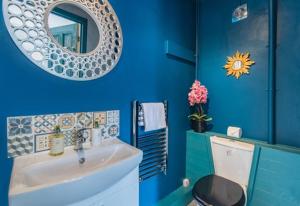 a blue bathroom with a sink and a mirror at Glastonbury, large House Stunning views 2 to 5 bedrooms, 3 receptions turn into bedrooms in Glastonbury