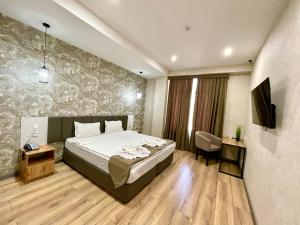 a bedroom with a bed and a television in a room at Alpha Plaza Hotel & SPA in Tashkent