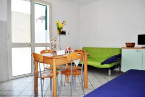 - un salon avec une table, des chaises et un canapé dans l'établissement Leuca Apartments - Happy Rentals, à Leuca