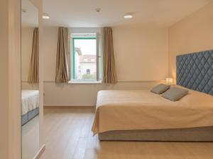 a bedroom with a bed and a window at Šangulin Palace V in Biograd na Moru