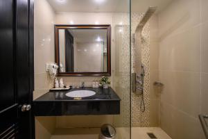 y baño con lavabo y ducha acristalada. en Rosaleen Boutique Hotel en Hue