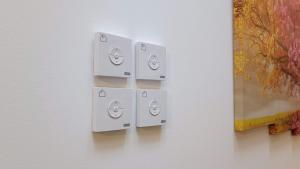 four white switches on a wall with a painting at Savenaantico9 in Bologna