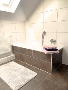 a bathroom with a bath tub and a rug at Kastanienhof in Südbrookmerland