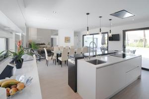 a kitchen and dining room with white and black appliances at Villa Alfazema IV in Aroeira