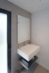 a bathroom with a white sink and a mirror at Villa Alfazema IV in Aroeira