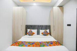 een slaapkamer met een groot wit bed met kleurrijke kussens bij Hotel The RASA at Vasundhara in Ghaziabad