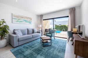 Una sala de estar con un sofá y un televisor. en Villa Drop in, en Sagres