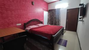 a red bedroom with a bed and a table at Gokulam Holiday Home in Munnar