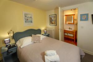 a bedroom with a large bed with two towels on it at Logis Cote Loire - Auberge Ligerienne in Blois