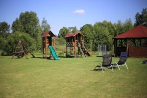 a park with a playground with two chairs in the grass at Karkonoska Chatka in Mysłakowice