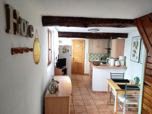 una cucina e una sala da pranzo con tavolo e bancone di Confortable maison de village en pierre typique a Moltig les Bains