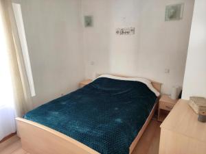 una piccola camera con un letto con una coperta verde di Confortable maison de village en pierre typique a Moltig les Bains