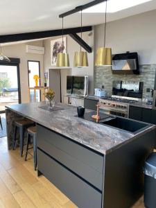 a kitchen with a large counter top in a room at Au cœur de la Pinède de 1 à 4 personnes in Langlade