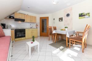 a kitchen and living room with a table and chairs at Ferienwohnung Waldblick auf dem Ferienhof Eschen in Moorweg