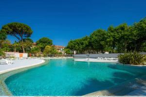 a swimming pool with blue water in a resort at Camping Sept Fonts Agde in Agde