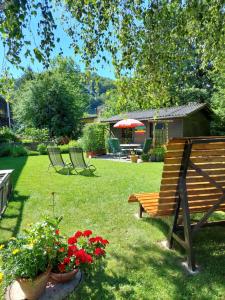 eine Holzbank in einem Garten mit Blumen in der Unterkunft Gästehaus Daurer in Reinsberg