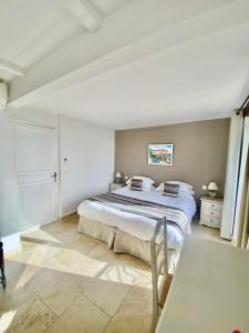 ein Schlafzimmer mit einem großen Bett und einem Tisch in der Unterkunft Auberge du Vieux Château in Cabris