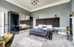 een slaapkamer met een groot bed en een grote spiegel bij The York Place Residence in Edinburgh
