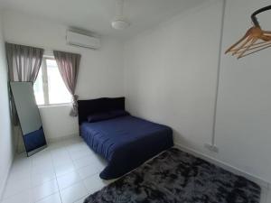 a bedroom with a blue bed and a rug at Khaleesi Afamosa Residency Homestay in Kampong Alor Gajah