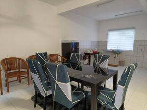 a dining room table with chairs and a laptop on it at Khaleesi Afamosa Residency Homestay in Kampong Alor Gajah