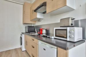 eine Küche mit einer Arbeitsplatte und einer Mikrowelle in der Unterkunft Appartement Quartier Hotel de Ville in Paris