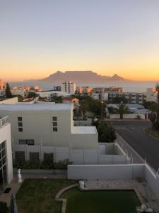 a view from the roof of a house with the sunset at Imany Guest House in Bloubergstrand