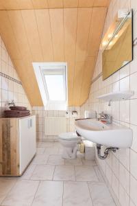 a bathroom with a sink and a toilet and a window at Ferienwohnung Mühlenblick auf dem Ferienhof Eschen in Moorweg