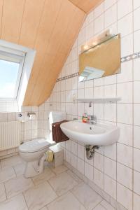 a bathroom with a toilet and a sink at Ferienwohnung Mühlenblick auf dem Ferienhof Eschen in Moorweg