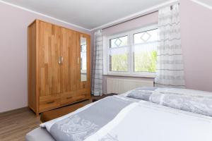 a bedroom with a bed and a wooden cabinet at Ferienwohnung Mühlenblick auf dem Ferienhof Eschen in Moorweg