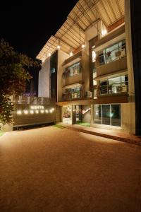 an empty parking lot in front of a building at night at Aureole Mrida - A Boutique Hotel in Lonavala