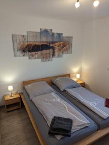 a bedroom with two beds and a painting on the wall at Ferienwohnung Am Kleinen Haff in Garz-Usedom