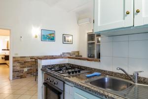 een keuken met een wastafel en een fornuis bij Palmiro in Castiglione della Pescaia