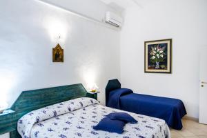 een slaapkamer met een blauw bed en een blauwe stoel bij Palmiro in Castiglione della Pescaia