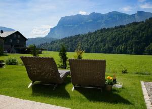 two chairs sitting on a lawn with mountains in the background at Haus Sonne & SPA in Bizau