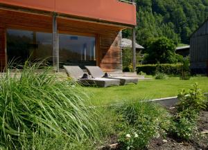 a group of chairs sitting on a lawn in front of a house at Haus Sonne & SPA in Bizau