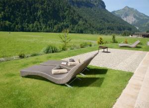 a bench sitting on the grass in a field at Haus Sonne & SPA in Bizau