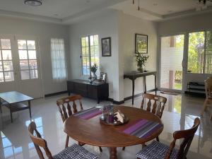 a living room with a wooden table and chairs at บ้านเสาวภา Baan Saowapa in Ban Tha Long Hip