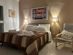 1 dormitorio con 1 cama con 2 lámparas y 1 silla en Artemide Home, en Taranto