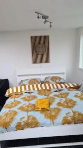 a bedroom with a bed with a yellow shirt on it at Tiny house Wassenaar in Wassenaar