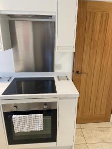 uma cozinha com um lavatório e um fogão forno superior em High Hedges Apartment A em Oxford