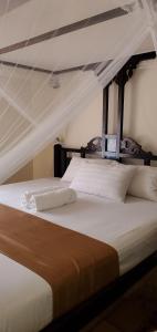a bed in a room with a canopy bed at Mangos Villas - Chiara in Kilifi