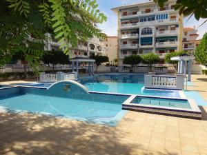 a swimming pool in front of a building at Apartment Viñamar 6 La Mata in La Mata