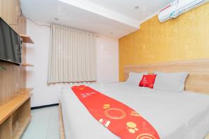 ein Schlafzimmer mit einem Bett mit einer roten Decke darauf in der Unterkunft RedLiving Apartemen Gateway Pasteur - Sean Hospitality in Bandung