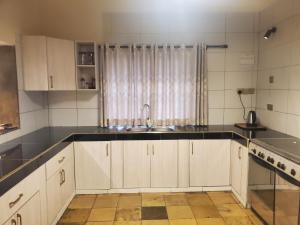 a kitchen with white cabinets and a sink at Mangos Villas - Chiara in Kilifi