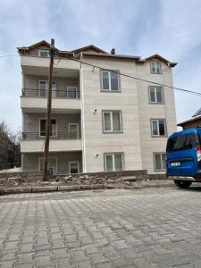 een blauw busje geparkeerd voor een gebouw bij Cappadocia 4 Luxury Aparts in Urgup