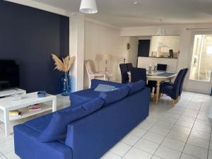 sala de estar con sofá azul y mesa en Maison chaleureuse proche de toutes commodités « Le LINA », 
