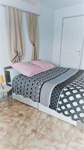 1 dormitorio con 1 cama con edredón blanco y negro en Au Coeur du Jura, Logement au calme en Champagnole