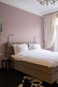 a bedroom with a large bed with white pillows at Suite 137, luxe verblijf midden in de bollenstreek in Lisse