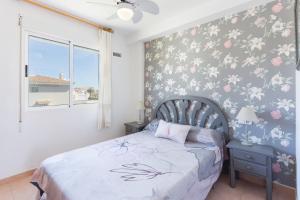 オリーバにあるCarmenのベッドルーム1室(ピンクの花が飾られた壁のベッド1台付)