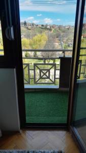 uma vista para uma varanda com uma mesa fora de uma janela em Kuman Apartments em Kumanovo